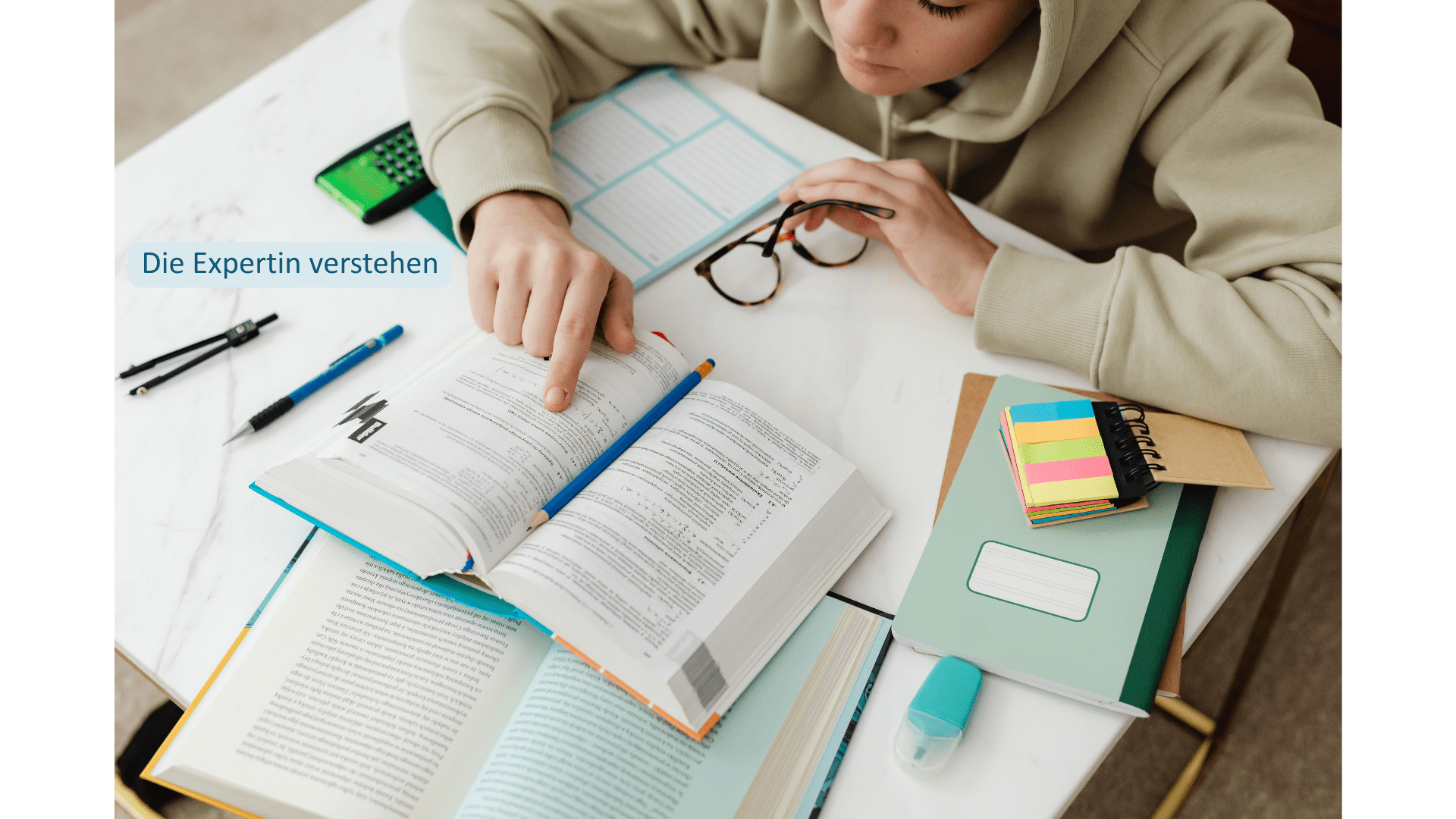 Frau arbeitet konzentriert mit Büchern und Notizen – Expertenmuster beim Imposter-Syndrom