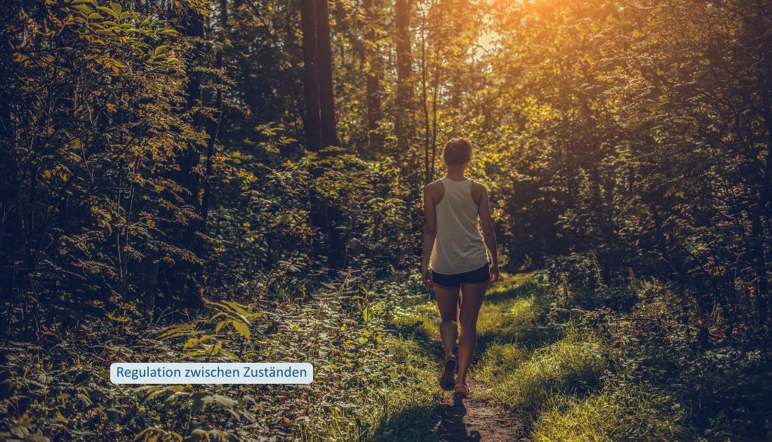 Frau geht auf einem schmalen Waldweg durch wechselnde Bereiche von Licht und Schatten.
