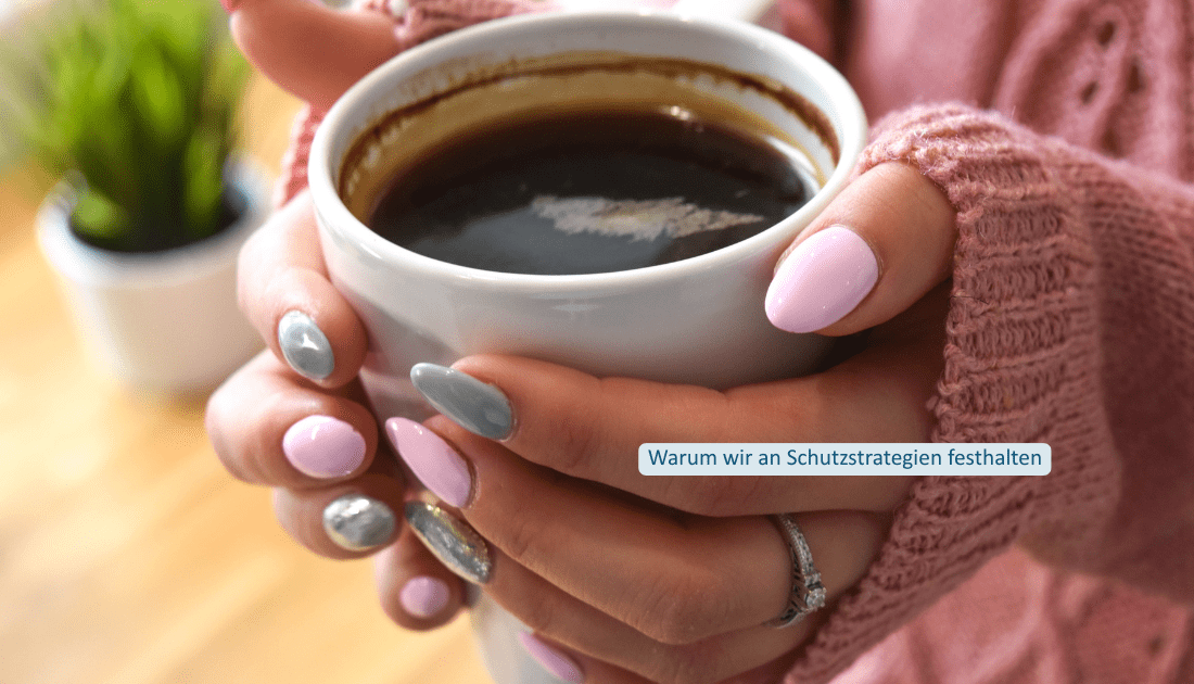 Hände halten eine Tasse Kaffee; eingeblendeter Text: Warum wir an Schutzstrategien festhalten.